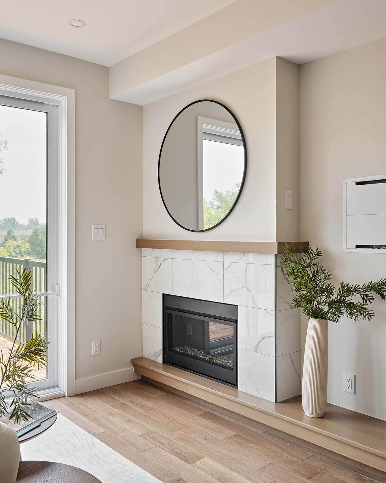 Tiled fireplace with round mirror in the living room