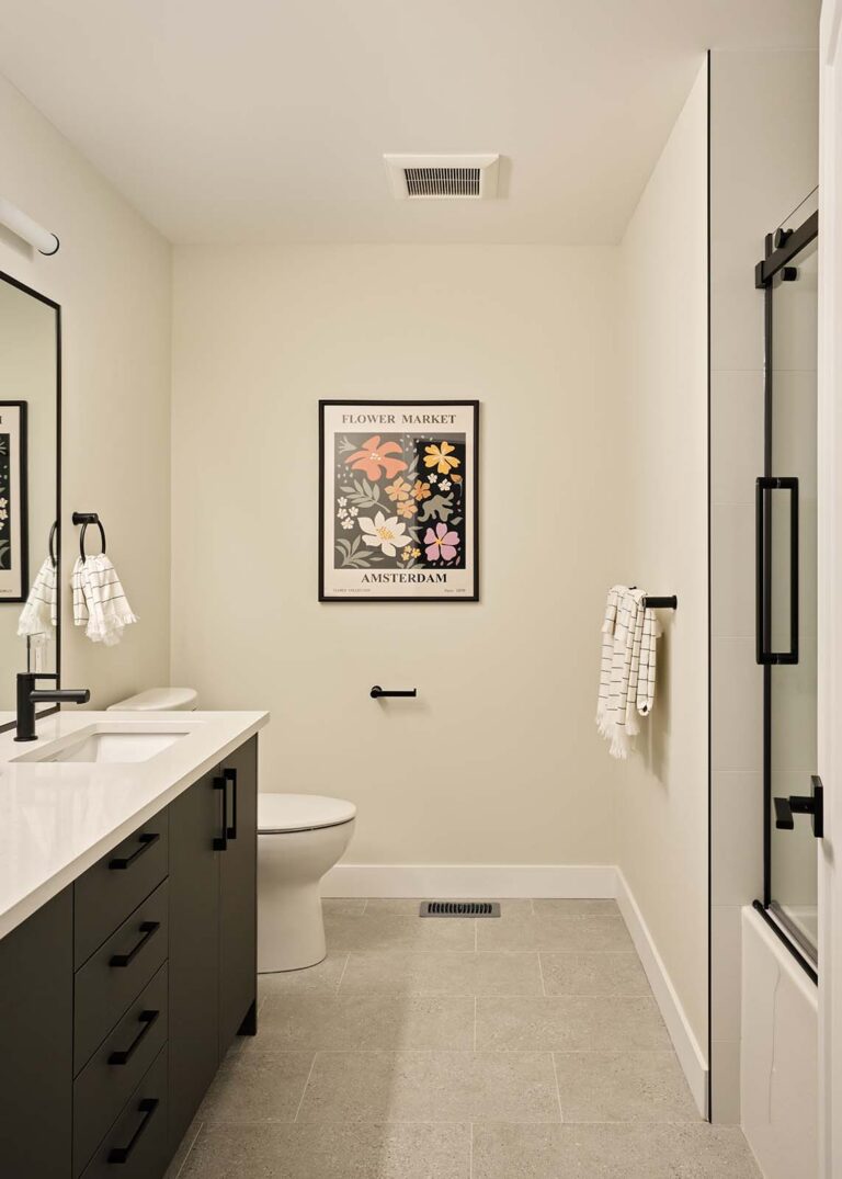 Full bathroom with dark vanity and glass shower