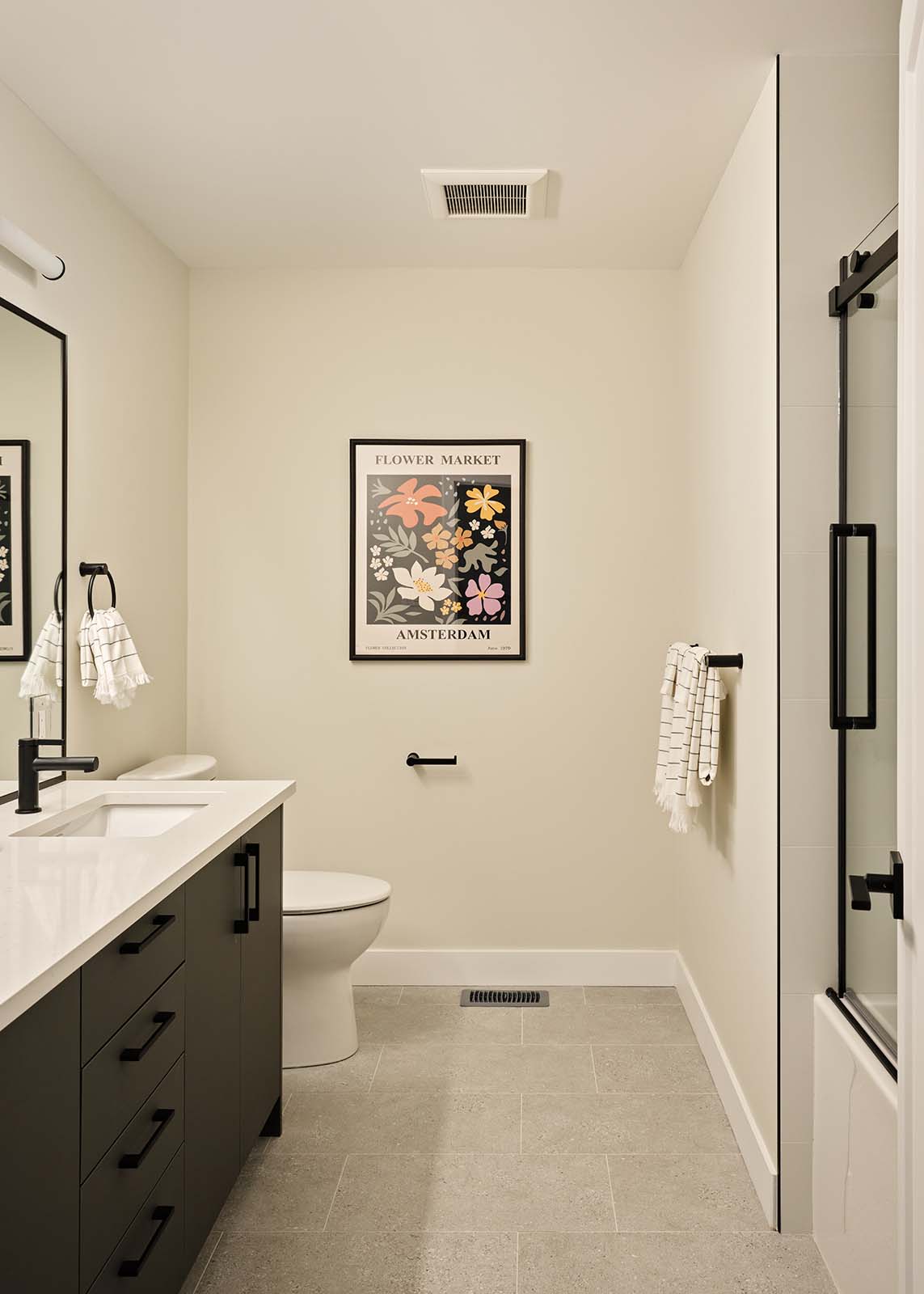 Full bathroom with dark vanity and glass shower