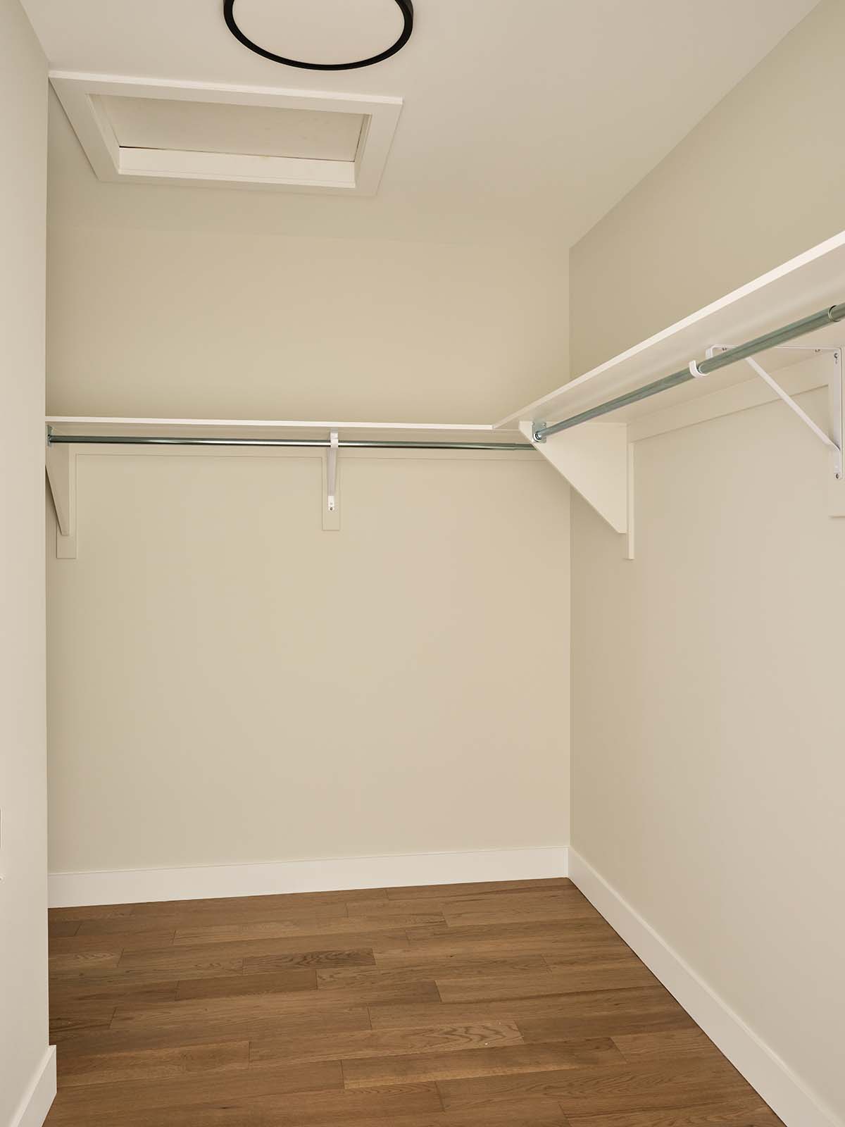 Walk-in closet with wood flooring