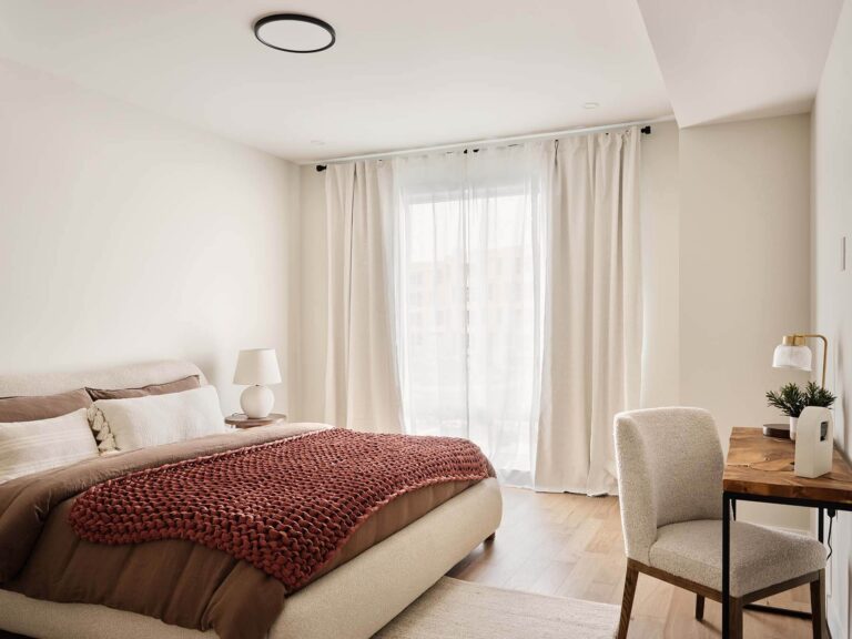Primary bedroom with desk and floor-length curtains
