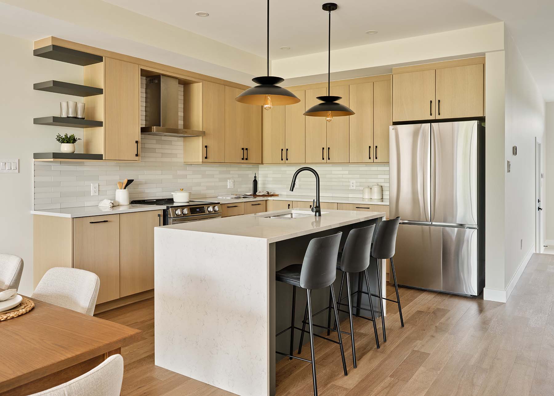 Light wood kitchen with waterfall island and bar seating